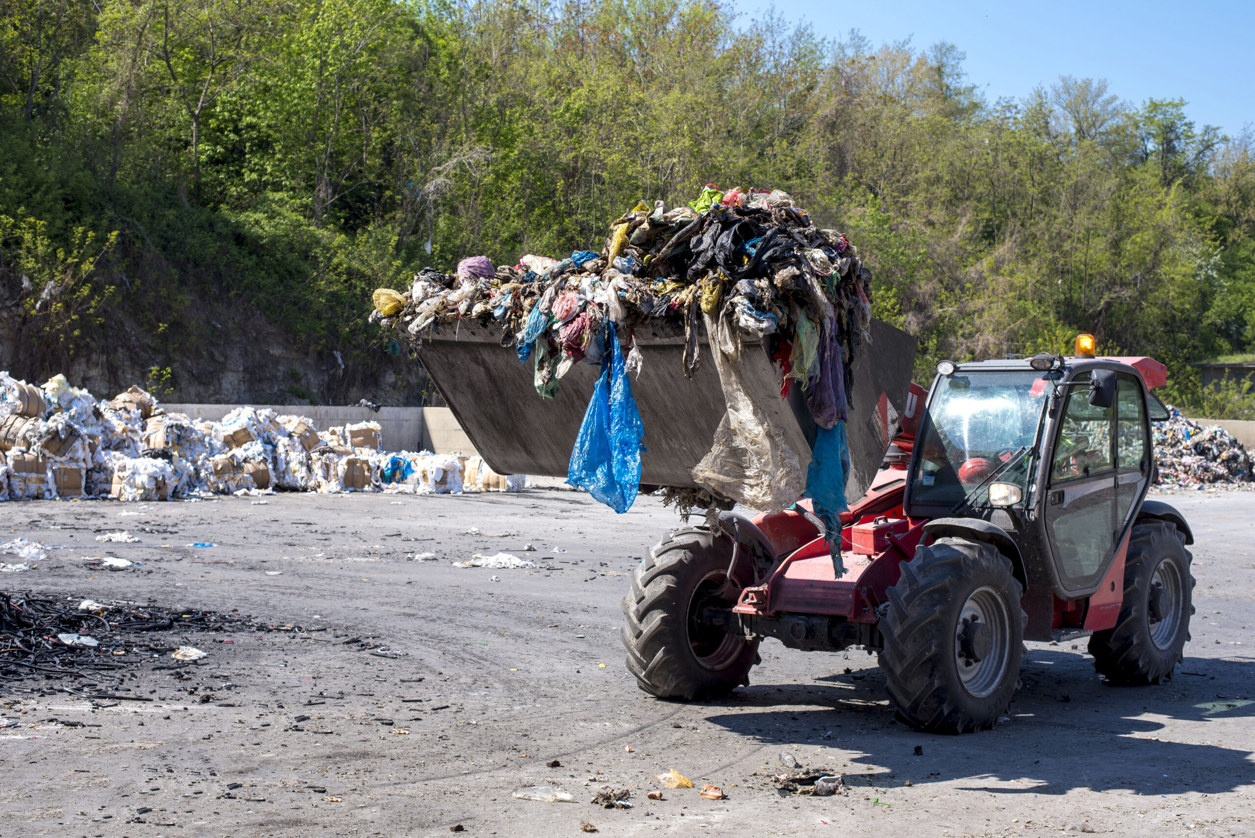 Home wheel loader transporting municipal waste waste treatment plant